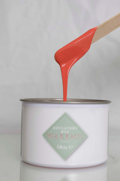 Waxxmii Rose Cream Soft Wax smooth consistency shown dripping from applicator stick